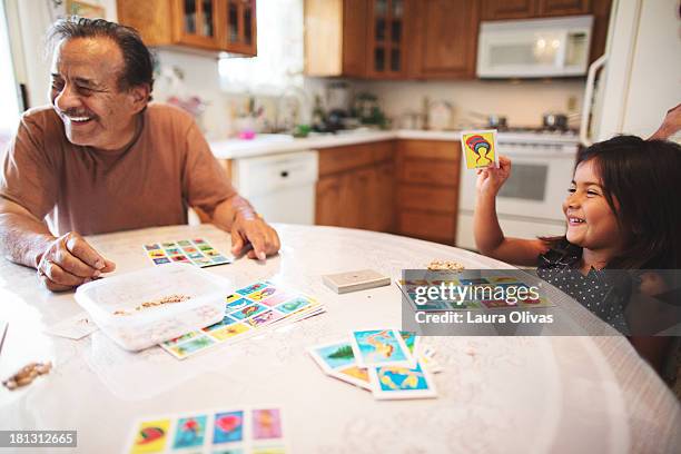 grandpa and granddaughter play a board game - family game stock-fotos und bilder