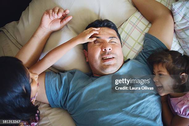 daughter's waking up their father - kids sleep in bed stock-fotos und bilder