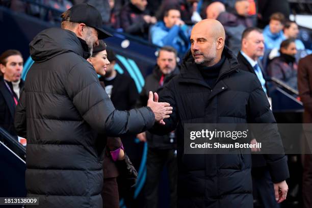 Juergen Klopp, Manager of Liverpool, and Pep Guardiola, Manager of Manchester City, interact prior to the Premier League match between Manchester...