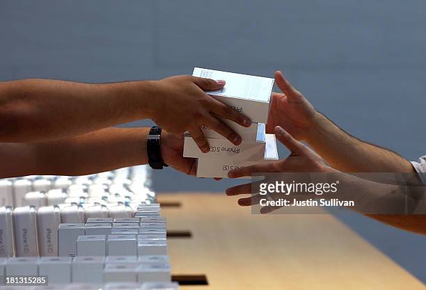 Apple Store employees pass boxes of the new Apple iPhone 5S on September 20, 2013 in Palo Alto, California. Apple launched two new models of iPhone:...