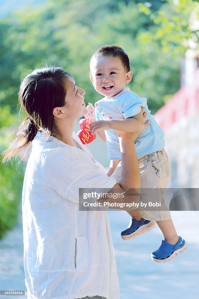 Young mother holds her son playing with him