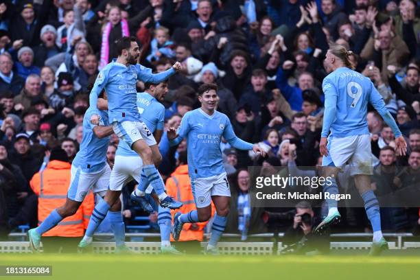 Erling Haaland of Manchester City celebrates with teammates after scoring the team's first goal during the Premier League match between Manchester...