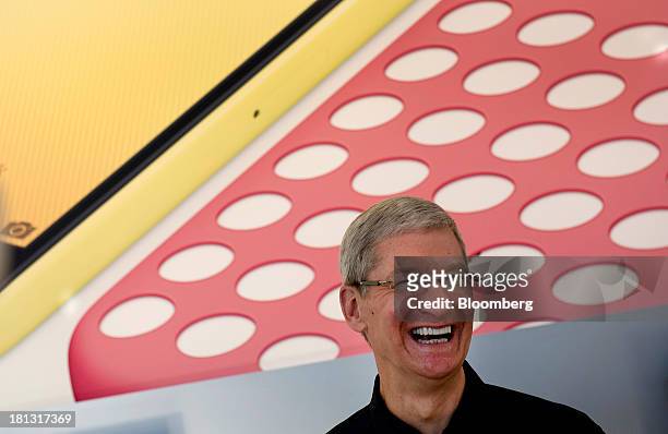 Tim Cook, chief executive officer of Apple Inc., smiles while greeting customers during the launch of the iPhone 5c and 5s at the company's new...