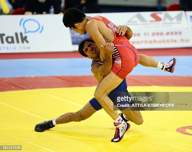 Armenia's Roman Amoyan fights with South Korea's Gyujin Choi during the men's Greco-Roman during the men's free style 55 kg category during the...