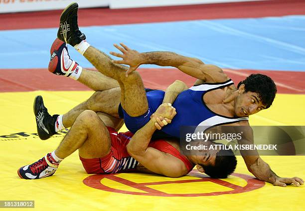 Armenia's Roman Amoyan fights with South Korea's Gyujin Choi during the men's Greco-Roman during the men's free style 55 kg category during the...