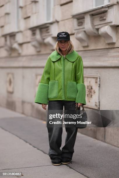 Karin Teigl seen wearing Cole Buxton black logo cap, Baum & Pferdgarten green leather jacket with fake fur details / collar and sleeves, H&M grey...