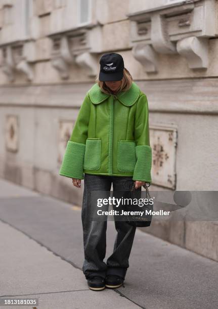 Karin Teigl seen wearing Cole Buxton black logo cap, Baum & Pferdgarten green leather jacket with fake fur details / collar and sleeves, H&M grey...