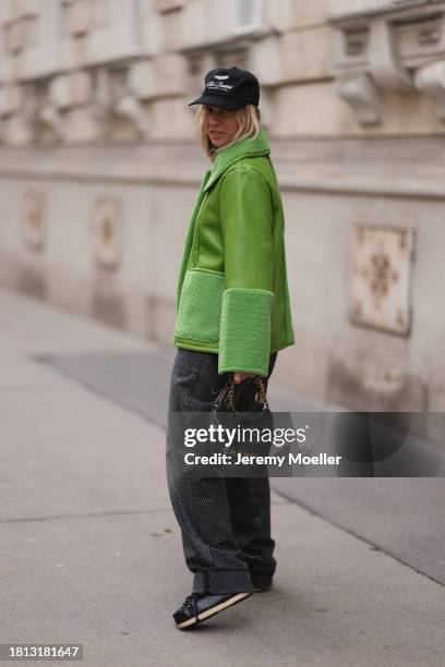 Karin Teigl seen wearing Cole Buxton black logo cap, Baum & Pferdgarten green leather jacket with fake fur details / collar and sleeves, H&M grey...