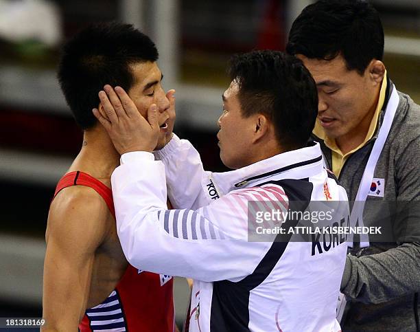 South Korea's Gyujin Choi is helped by his teammates against Armenia's Roman Amoyan during the men's Greco-Roman during the men's free style 55 kg...