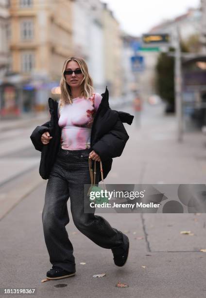 Karin Teigl seen wearing black sunglasses, KHY by Kylie Jenner black puffer / down jacket, H&M Studios grey sparkling wide leg jeans / denim pants,...