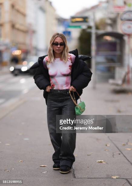 Karin Teigl seen wearing black sunglasses, KHY by Kylie Jenner black puffer / down jacket, H&M Studios grey sparkling wide leg jeans / denim pants,...
