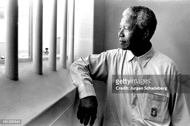 South Africa's first black President Nelson Mandela revisits his prison cell on Robben Island, where he spent eighteen of his twenty-seven years in...