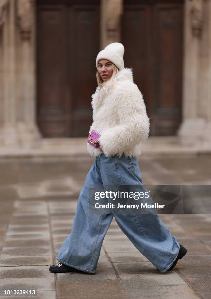 Karin Teigl seen wearing By Aylin Koenig cream white wool knit beanie, cream white fake fur teddy cropped jacket, The Frankie Shop light blue wide...