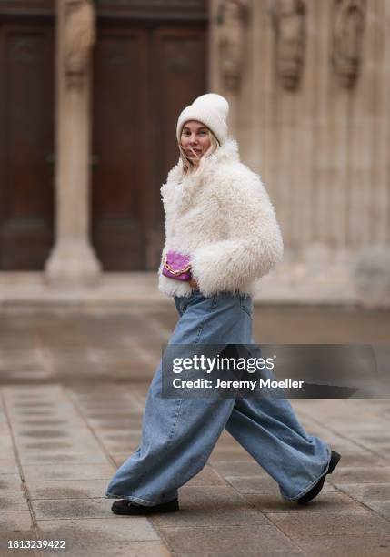 Karin Teigl seen wearing By Aylin Koenig cream white wool knit beanie, cream white fake fur teddy cropped jacket, The Frankie Shop light blue wide...