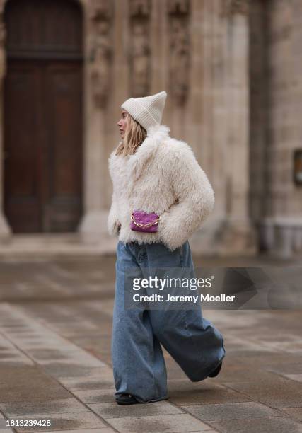 Karin Teigl seen wearing By Aylin Koenig cream white wool knit beanie, cream white fake fur teddy cropped jacket, The Frankie Shop light blue wide...