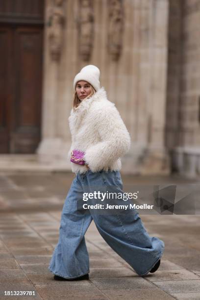 Karin Teigl seen wearing By Aylin Koenig cream white wool knit beanie, cream white fake fur teddy cropped jacket, The Frankie Shop light blue wide...