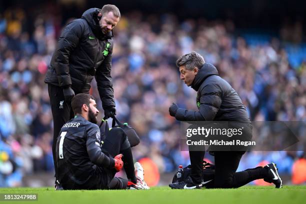 Alisson Becker of Liverpool receives medical treatment following the Premier League match between Manchester City and Liverpool FC at Etihad Stadium...