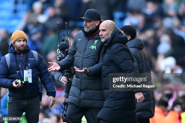 Juergen Klopp, Manager of Liverpool, and Pep Guardiola, Manager of Manchester City, interact after the draw in the Premier League match between...