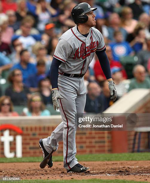 Freddie Freeman of the Atlanta Braves follows the flight of his three-run home run in the 3rd`inning against the Chicago Cubs at Wrigley Field on...