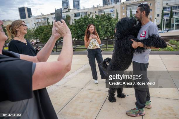 People react to a dog named Steve leaning on his owner in Habima Square on November 25, 2023 in Tel Aviv, Israel. A total of 50 hostages currently...