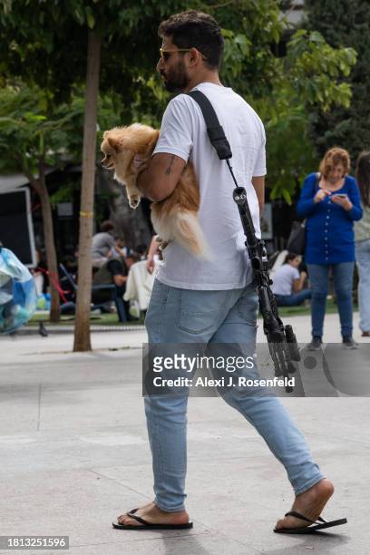 Off duty member of Israeli security forces holds a dog while walking on Shabbat morning in Dizengoff Square on November 25, 2023 in Tel Aviv, Israel....