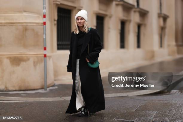 Karin Teigl seen wearing By Aylin Koenig cream white wool knit beanie, Mango cream white satin / silk long skirt, Chanel black wool knit sweater, H&M...