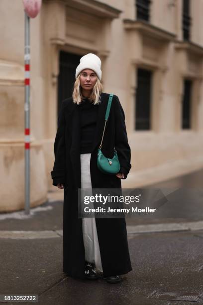 Karin Teigl seen wearing By Aylin Koenig cream white wool knit beanie, Mango cream white satin / silk long skirt, Chanel black wool knit sweater, H&M...