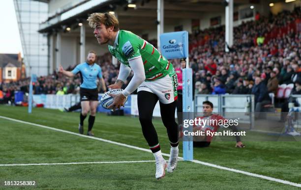 Ollie Hassell-Collins of Leicester Tigers celebrates scoring their sides first try after evading the tackle attempt of Santi Carreras of Gloucester...