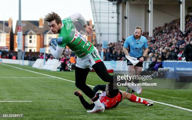Ollie Hassell-Collins of Leicester Tigers goes onto score their sides first try after evading the tackle attempt of Santi Carreras of Gloucester...