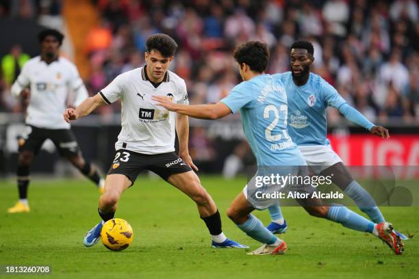 Fran Perez of Valencia CF on the ball whilst under pressure from Manu Sanchez of Celta Vigo during the LaLiga EA Sports match between Valencia CF and...