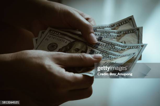 close up of someone hands holding and counting american dollar banknotes in hands. - billete de dólar estadounidense fotografías e imágenes de stock
