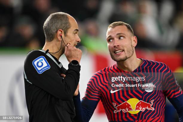 David Raum of RB Leipzig speaks with Assistant Referee Christian Leicher during the Bundesliga match between VfL Wolfsburg and RB Leipzig at...