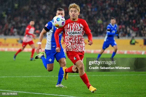 Ritsu Doan of Sport-Club Freiburg is put under pressure by Fabian Nuernberger of SV Darmstadt 98 during the Bundesliga match between Sport-Club...