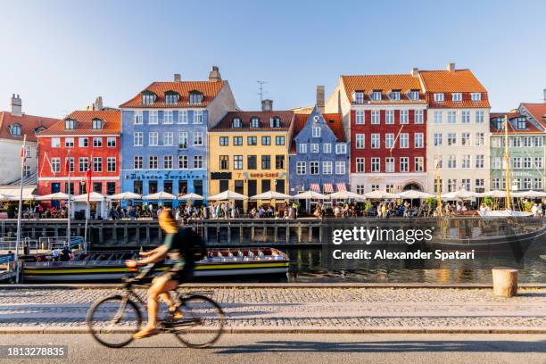 nyhavn harbour with restaurants and crowds of tourists on a sunny summer day, copenhagen, denmark - wonderlust stock-fotos und bilder