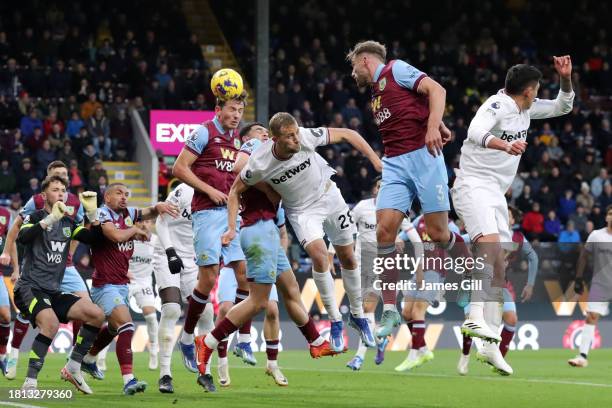 Tomas Soucek of West Ham United wins a header whilst under pressure from Sander Berge and Charlie Taylor of Burnley during the Premier League match...