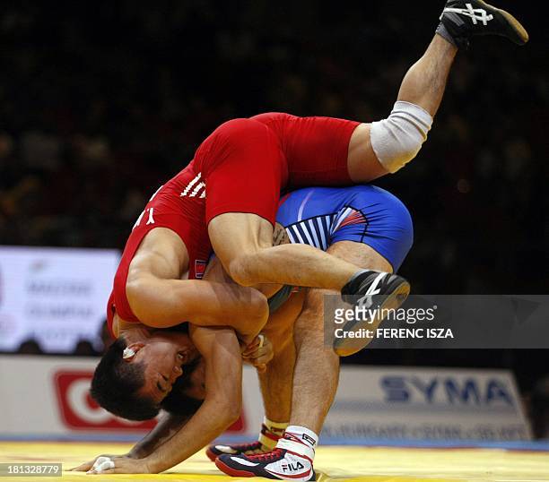People Republic of Korea's Won Chol Yun fights with Korea's Gyujin Choi during the final round of the men's Greco-Roman 55 kg category of the World...