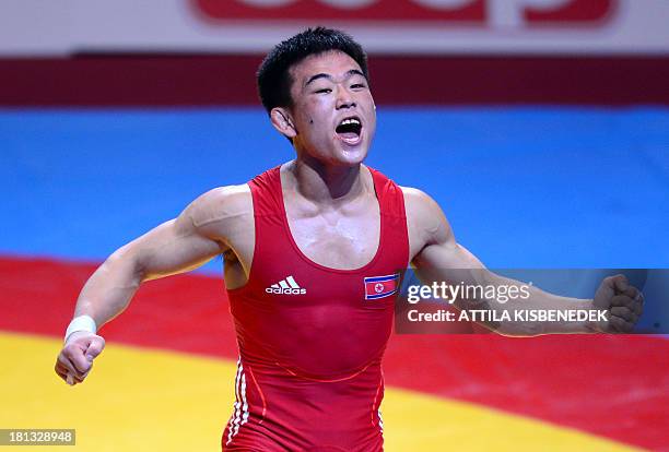 People Republic Korea's Won Chol Yun celebrates his victory over South Korea's Gyujin Choi after their fighting at the men's Greco-Roman style 55 kg...