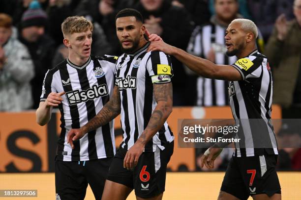 Jamaal Lascelles of Newcastle United celebrates with teammates Anthony Gordon and Joelinton after scoring the team's second goal during the Premier...