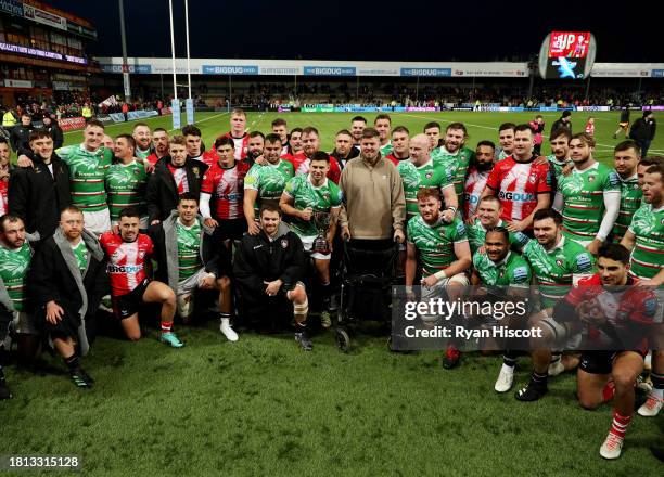 Ed Slater poses for a photograph with players of Leicester Tigers and Gloucester Rugby, as Ben Youngs of Leicester Tigers holds the Slater Cup, after...