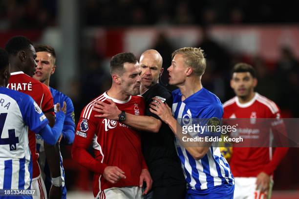 Referee, Anthony Taylor, intervenes as Harry Toffolo of Nottingham Forest clashes with Jan Paul van Hecke of Brighton & Hove Albion during the...
