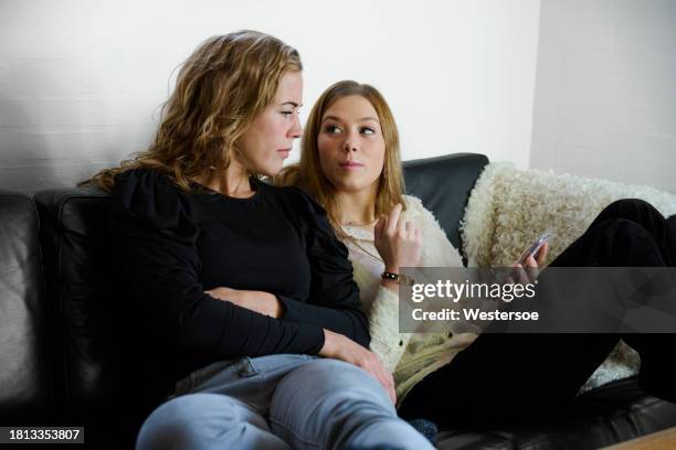 sisters discussing online dating sitting in sofa - sister stock pictures, royalty-free photos & images