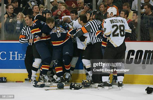 Mario Lemieux of the Pittsburgh Penguins, back center, is restrained by linesman Ray Scapinello after a fight with Brad Ference of the Florida...