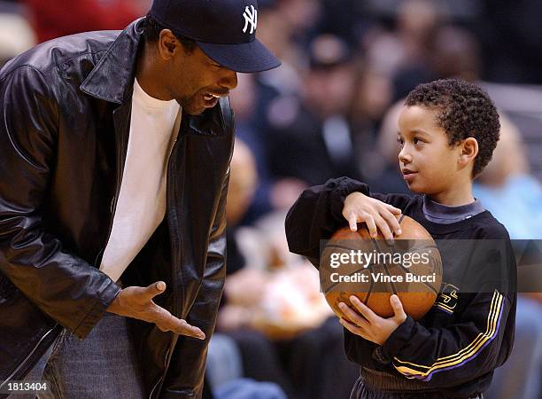 Actor Denzel Washington talks with Devean Fox, son of Laker player Rick Fox, at the game between the Los Angeles Lakers and the Seattle Supersonics...