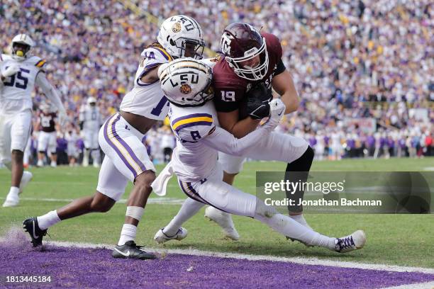 Jake Johnson of the Texas A&M Aggies catches the ball for a touchdown as Tony Grimes and Jayvon Thomas of the Texas A&M Aggies defend during the...