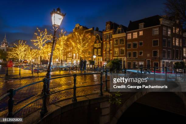 street lamp and light decorations in amsterdam, holland at night - amsterdam christmas stock pictures, royalty-free photos & images