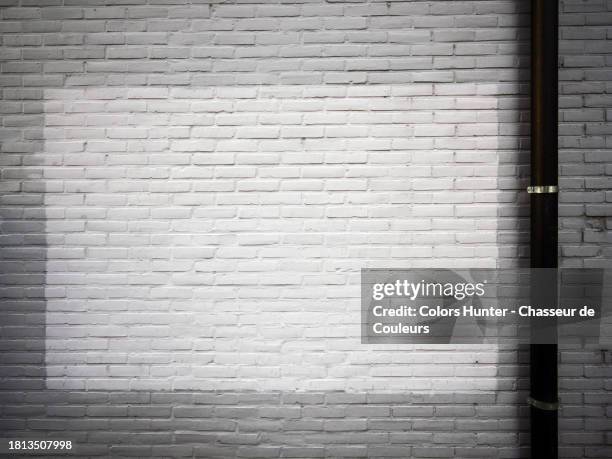 textured brick wall painted in white and grey with a pipe in brussels, belgium - newly industrialized country stock pictures, royalty-free photos & images