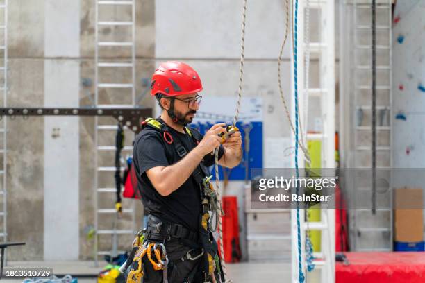 male climber doing final checks before climbing - rope high rescue stock pictures, royalty-free photos & images