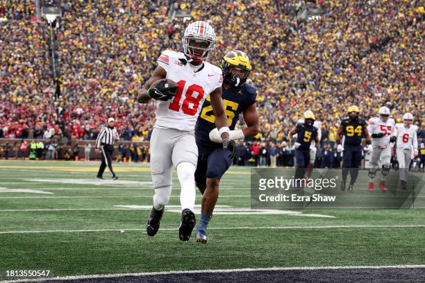 Marvin Harrison Jr. #18 of the Ohio State Buckeyes scores a touchdown against Junior Colson of the Michigan Wolverines during the fourth quarter in...