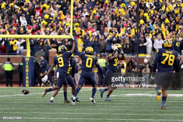 Rod Moore of the Michigan Wolverines celebrates with Mike Sainristil after an interception against Kyle McCord of the Ohio State Buckeyes late in the...