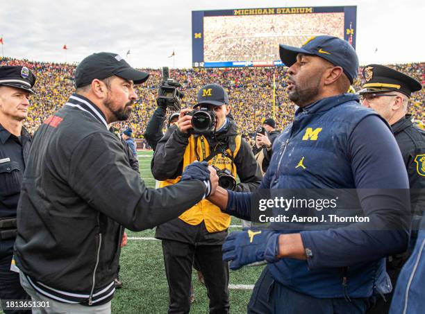 Head Football Coaches Ryan Day of the Ohio State Buckeyes and Sherrone Moore of the Michigan Wolverines shake hands after a college football game at...